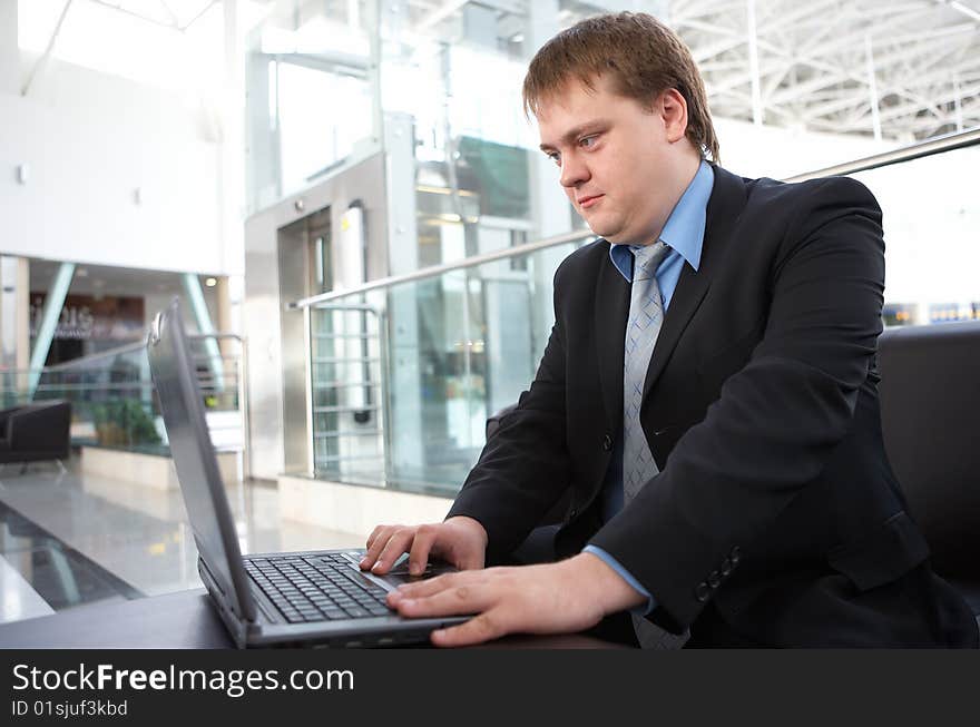 Happy young businessman with laptop