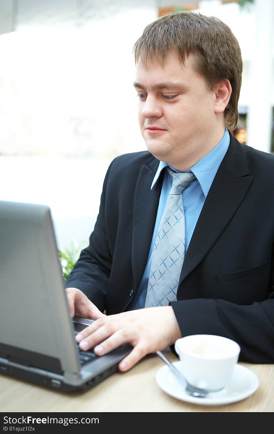 Happy young businessman with laptop in business building