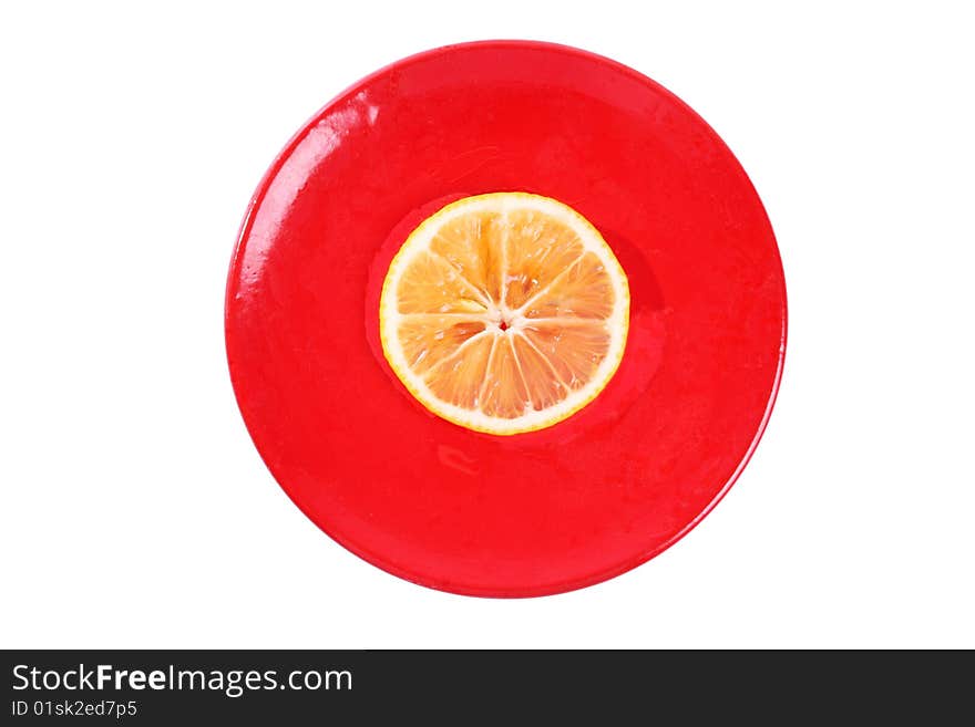 One slice of orange on a red plate