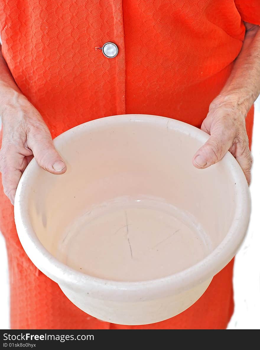 An old woman holding an empty plastic bucket. An old woman holding an empty plastic bucket