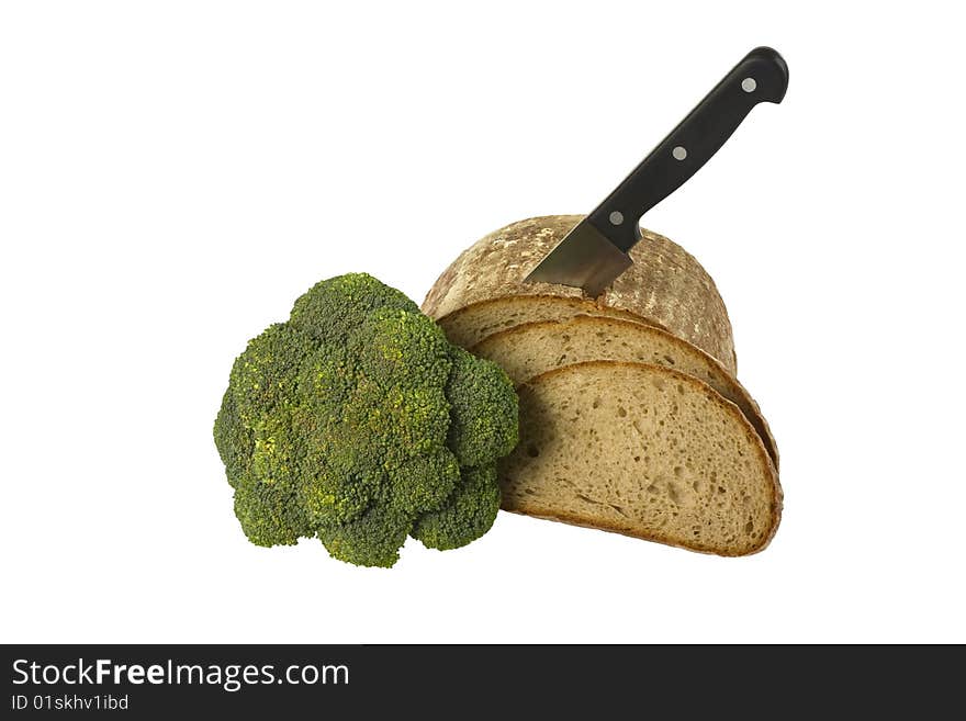 Loaf of bread with knife and broccoli isolated over white background