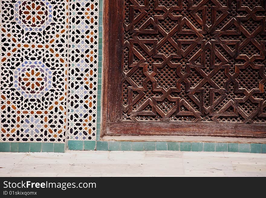 Detail of wood carving en mosaic tiles at Bou Inania Madrassa in Fez, Morocco