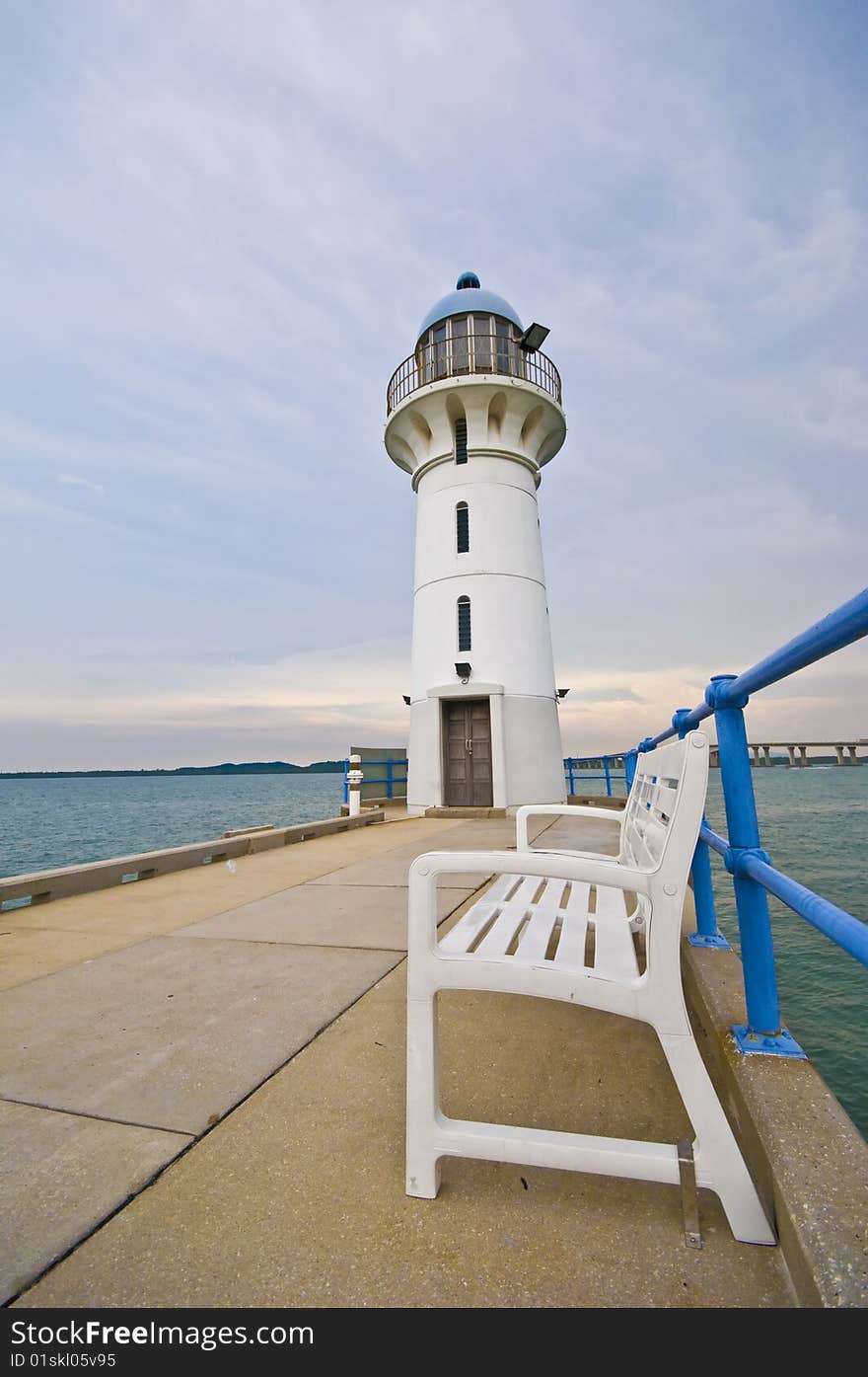 A scenic light house with a bench overlooking the vast ocean. A scenic light house with a bench overlooking the vast ocean.