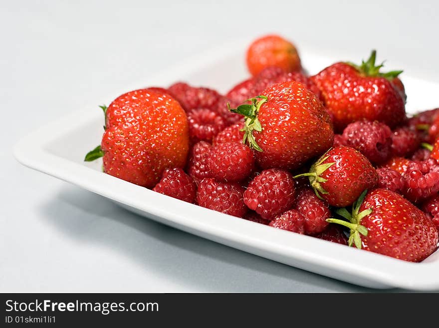 Summer Still Life with red strawberries on a white plate. Summer Still Life with red strawberries on a white plate.