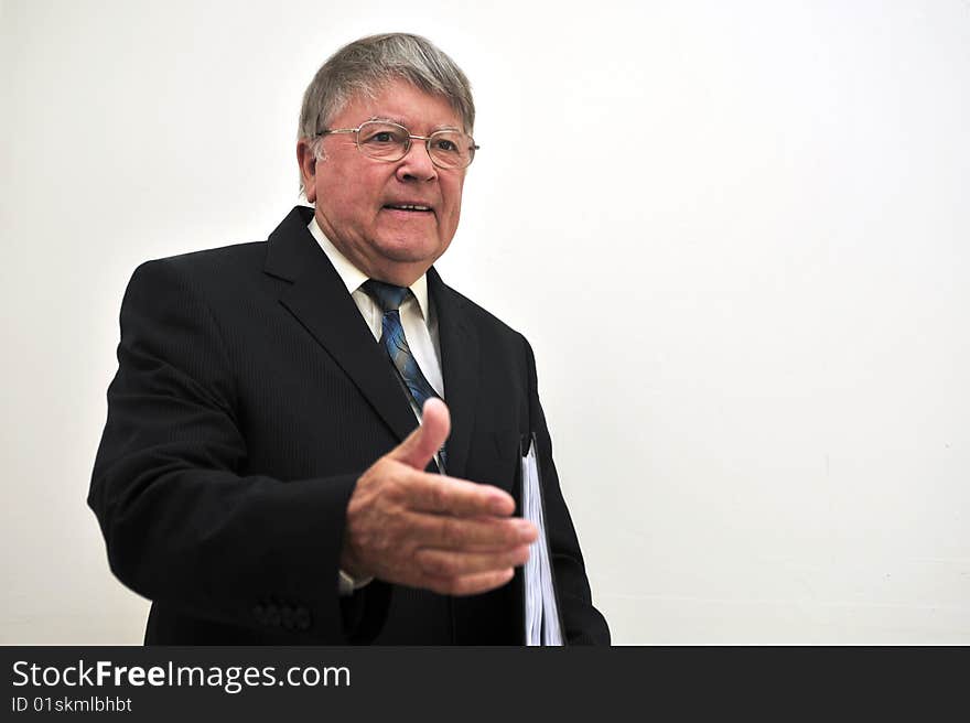 Businessman in suite and tie meeting client with file/folder in left hand, right hand extended for handshake, all isolated on white background, space for print. Businessman in suite and tie meeting client with file/folder in left hand, right hand extended for handshake, all isolated on white background, space for print.