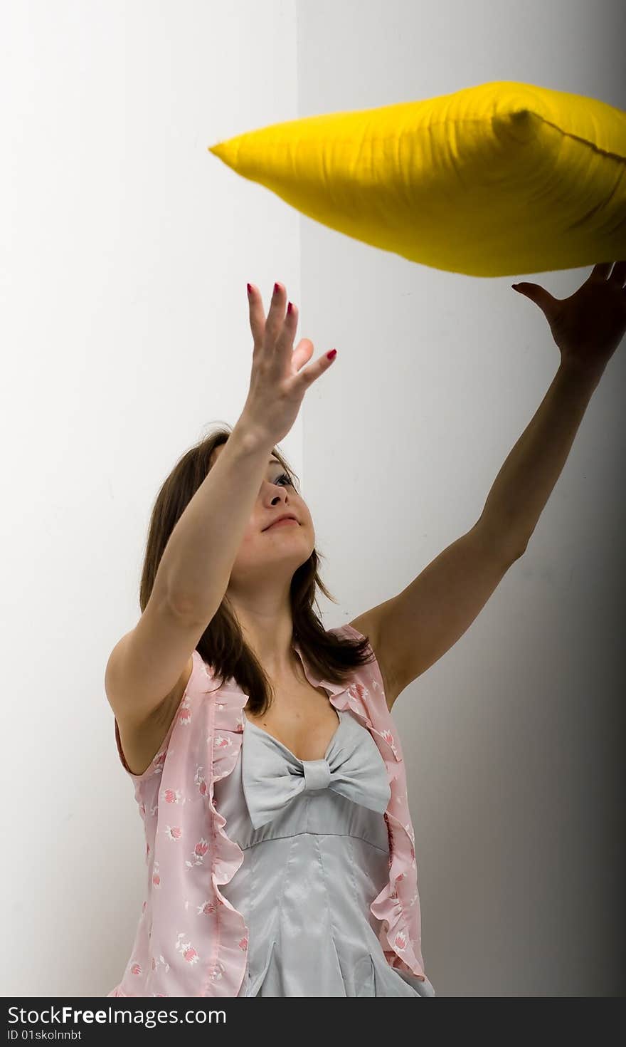 Pretty young girl with black hair isolated on white background, holding a yellow pillow. Pretty young girl with black hair isolated on white background, holding a yellow pillow