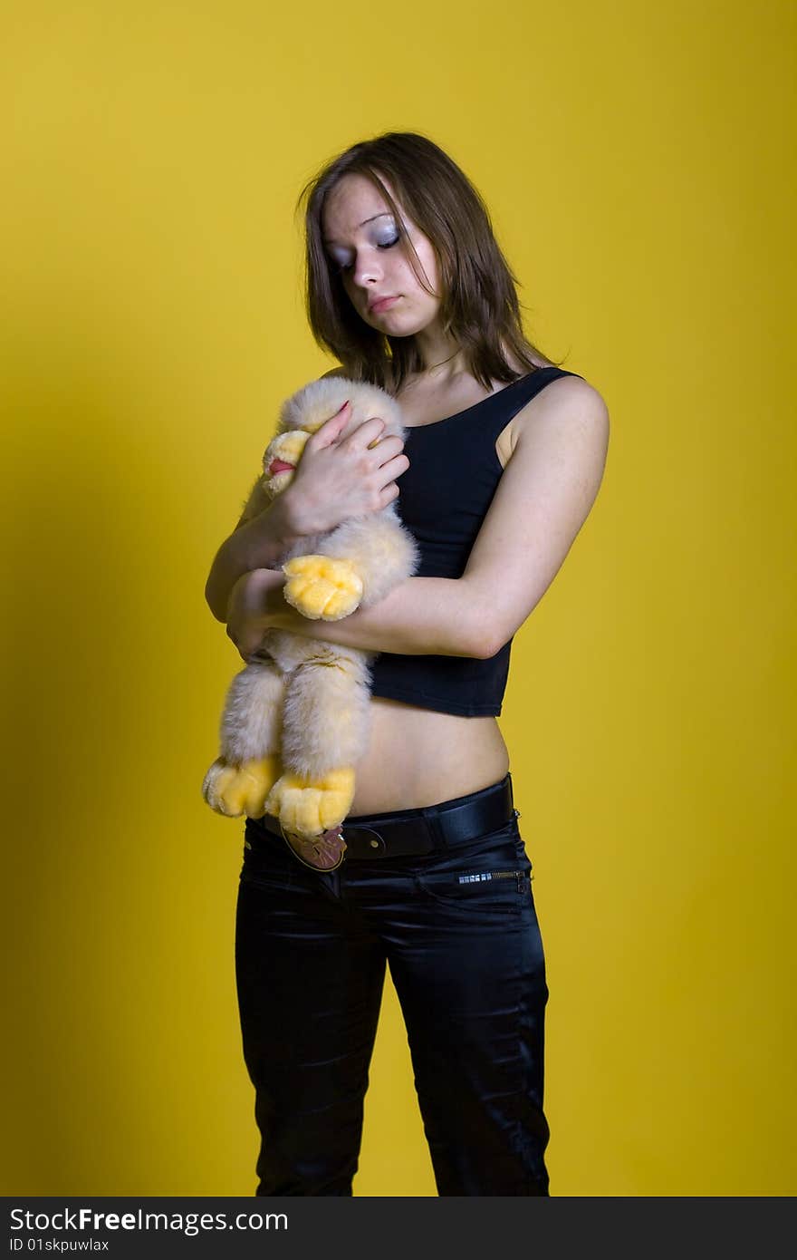 Girl with a toy - yellow monkey on yellow background. Girl with a toy - yellow monkey on yellow background