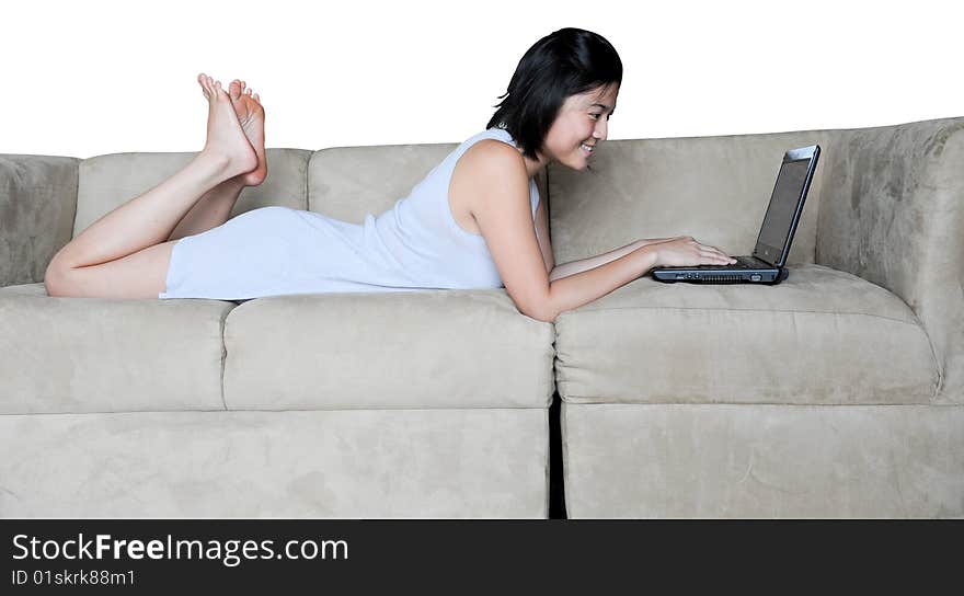 Beautiful Asian girl uses laptop at home on the couch. she is lying down. Beautiful Asian girl uses laptop at home on the couch. she is lying down.