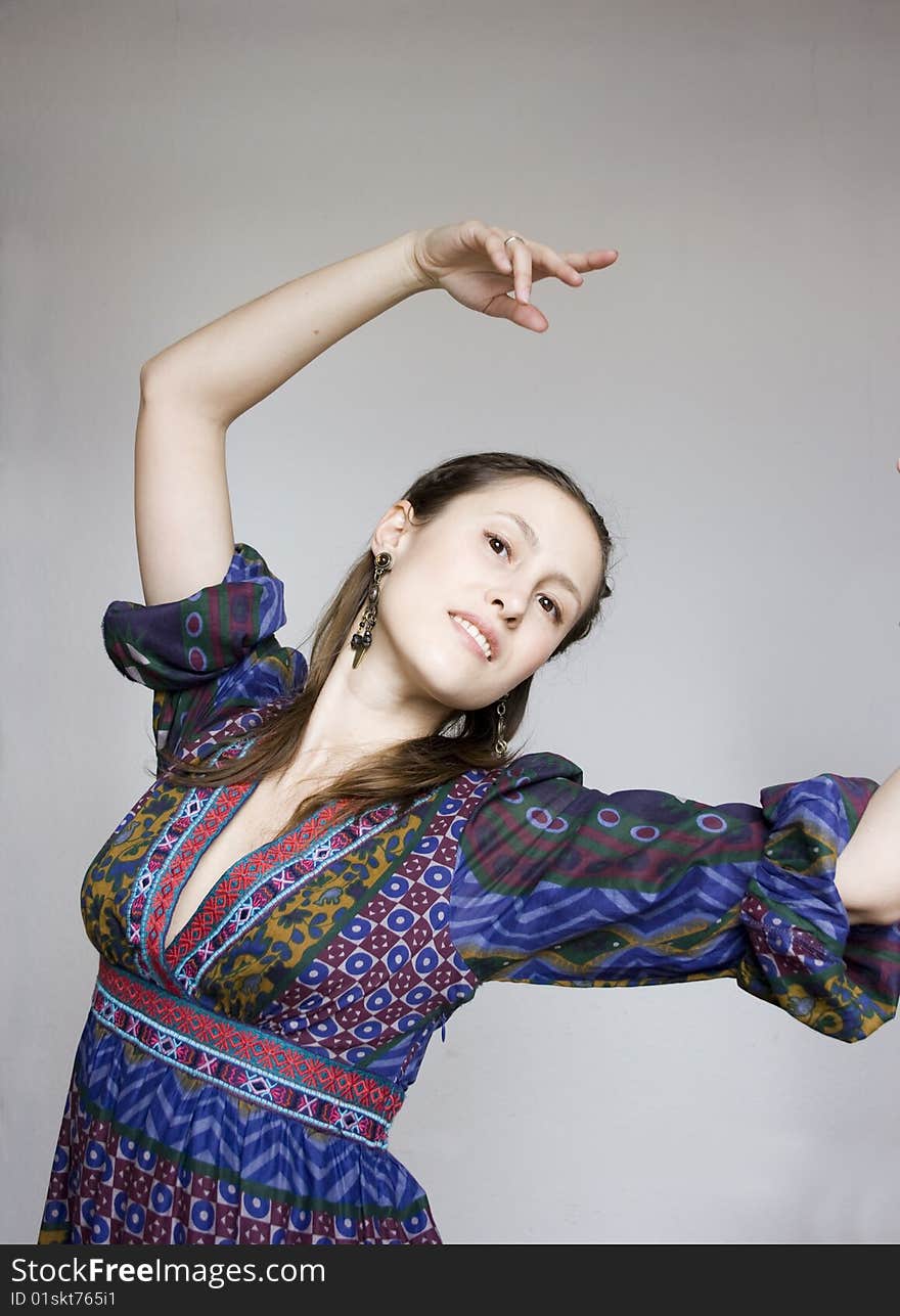 Portrait of young attractive dancing woman in gypsy costume on grey background. Portrait of young attractive dancing woman in gypsy costume on grey background