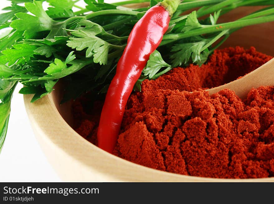 Fresh and powder red paprika with green parsley in wooden bowl and spoon. Fresh and powder red paprika with green parsley in wooden bowl and spoon