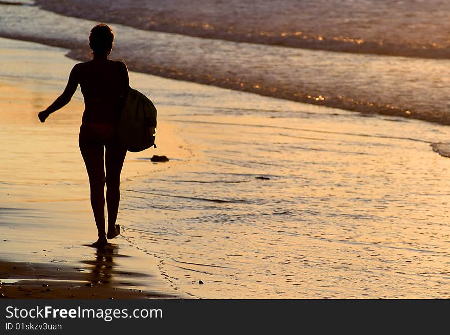 Silhouette of woman walking by the seaside