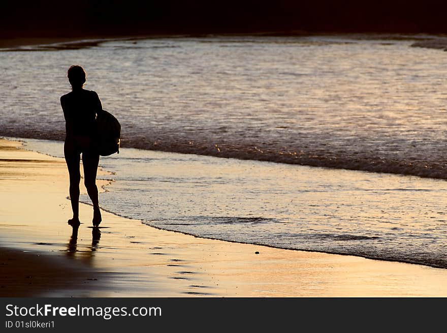 Silhouette of woman walking by the seaside