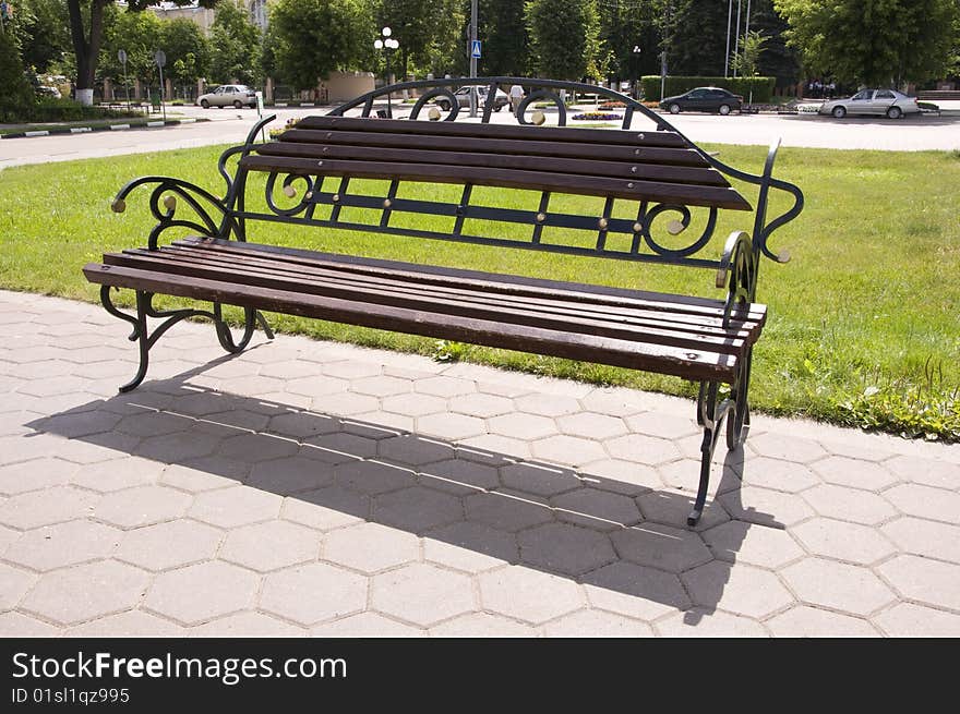 Wooden bench with forged railing in the park. Wooden bench with forged railing in the park