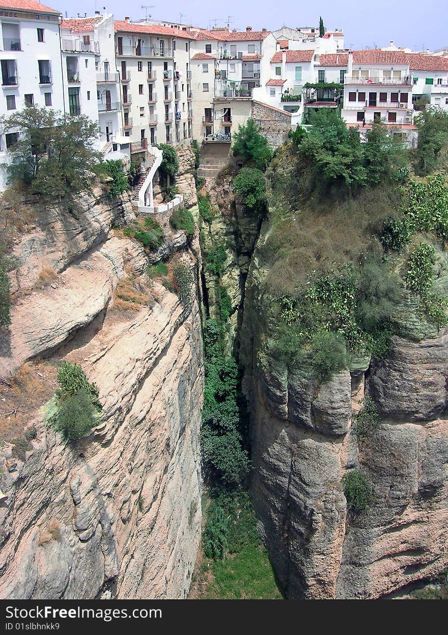 Ronda is a city in the Spanish province of Malaga. The houses in Ronda sit on the cliff over the chasm which divides the area. Ronda is a city in the Spanish province of Malaga. The houses in Ronda sit on the cliff over the chasm which divides the area.