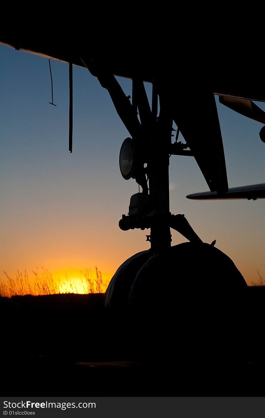 Aircraft nose wheel Silhouette against setting sun. Aircraft nose wheel Silhouette against setting sun