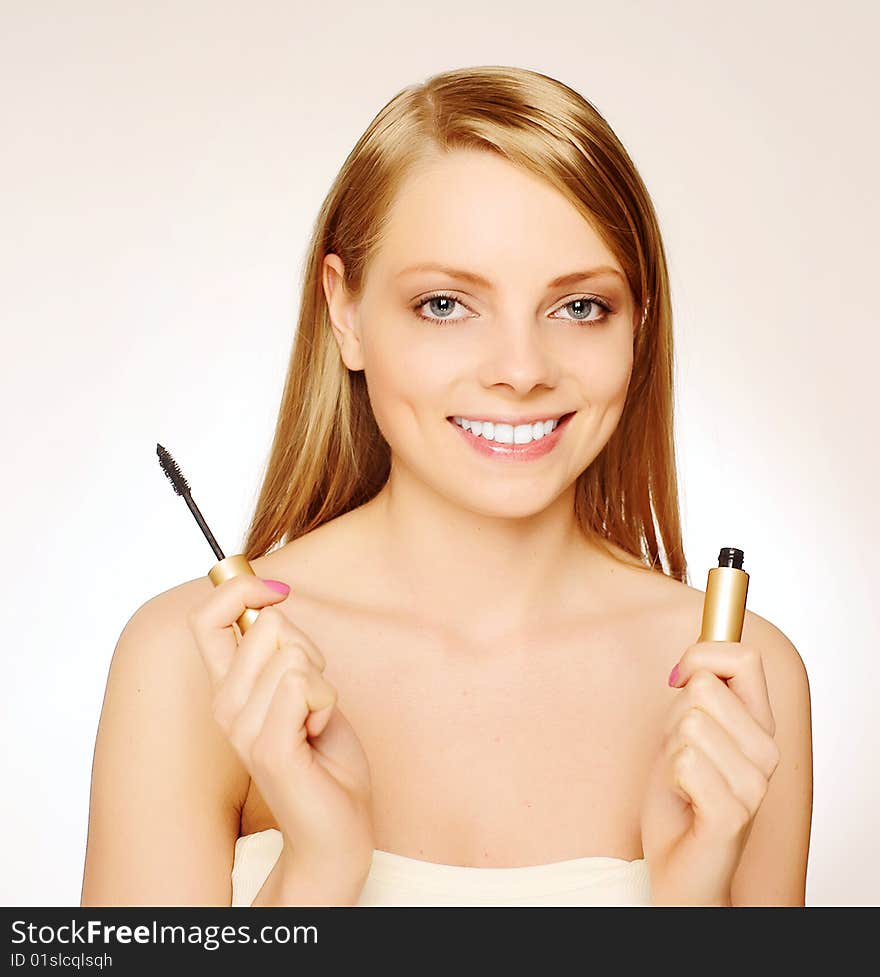 Pretty woman applying make up.