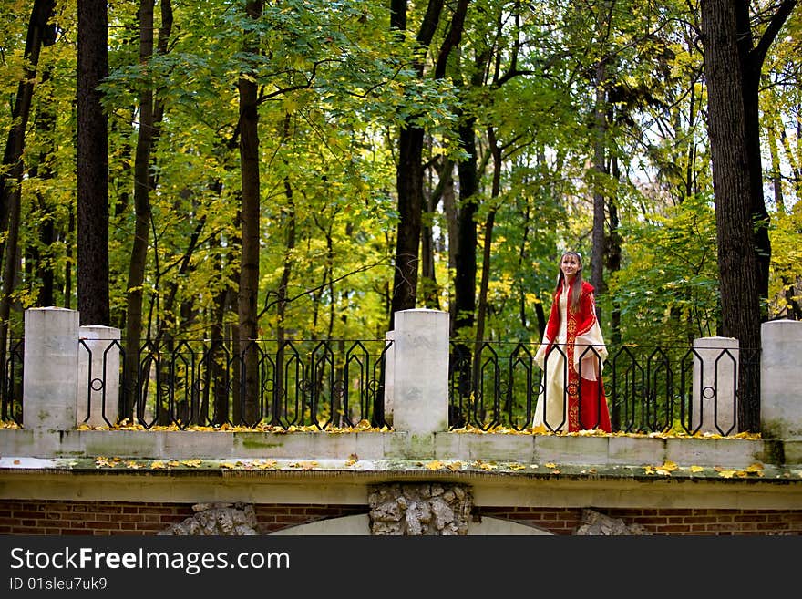 Lady in medieval red dress in the autumn forest. Lady in medieval red dress in the autumn forest