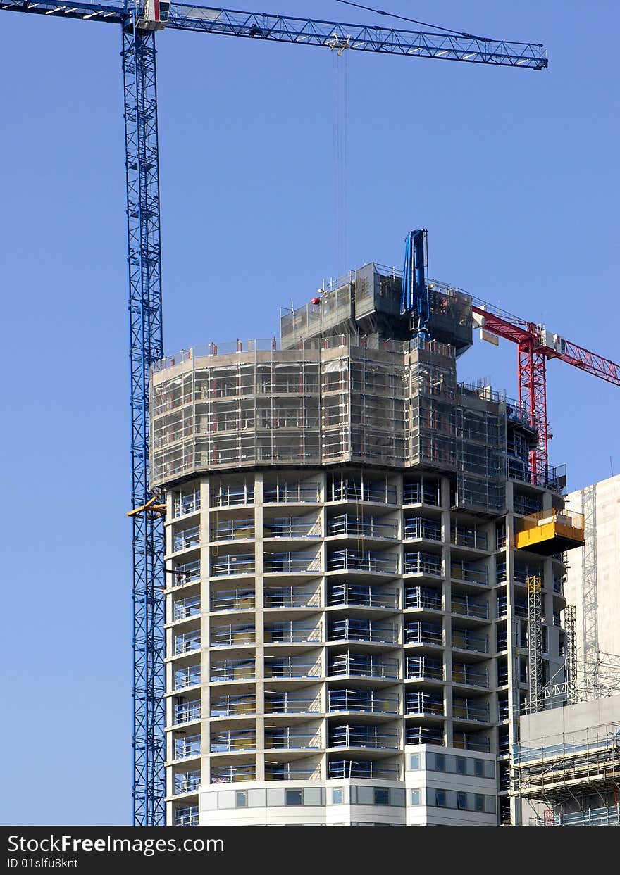 Modern building under construction against clear blue sky. Modern building under construction against clear blue sky