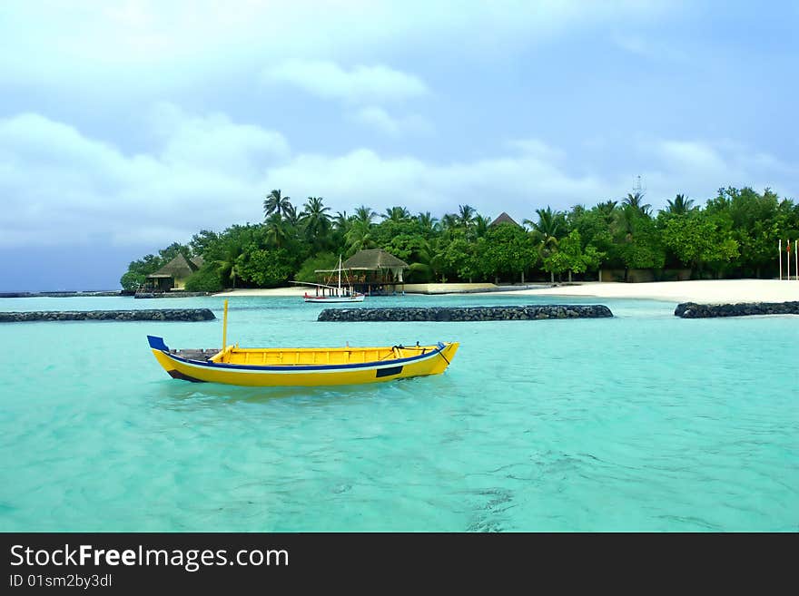 Beautiful seascape with boat and palm lined beach.