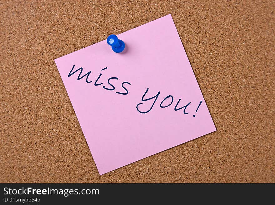 Pink note with blue pin and miss you text