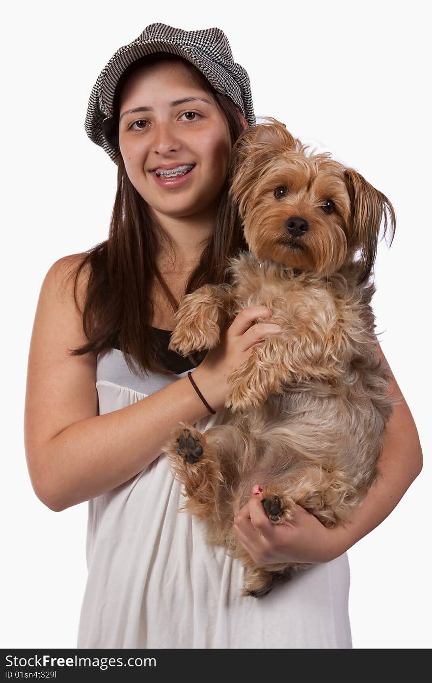 Cute young teenage Hispanic girl with braces wearing a hat holding onto pet Yorkshire Terrier dog. Cute young teenage Hispanic girl with braces wearing a hat holding onto pet Yorkshire Terrier dog