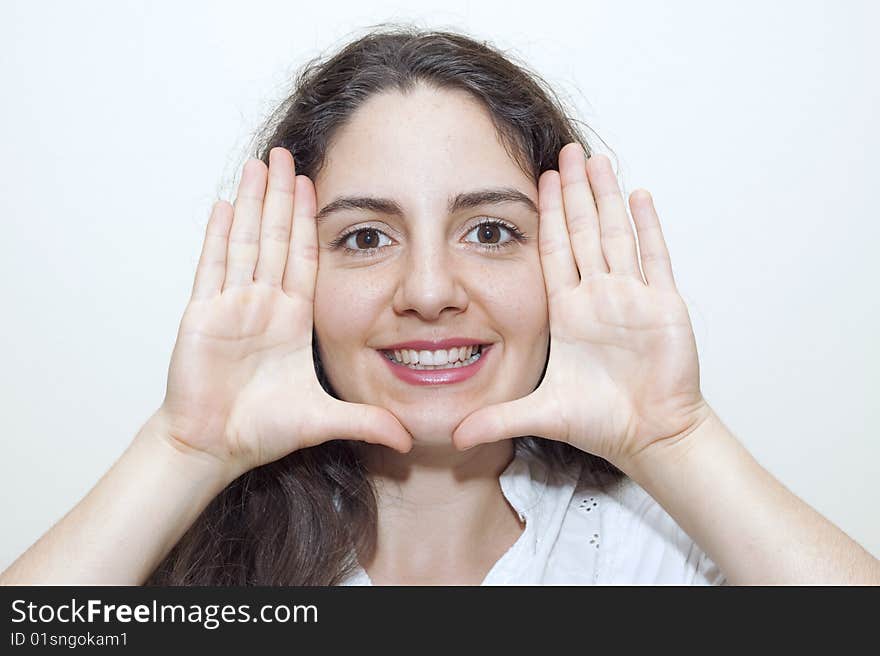 Young woman, making a frame with her hands around her face, smiling. Young woman, making a frame with her hands around her face, smiling