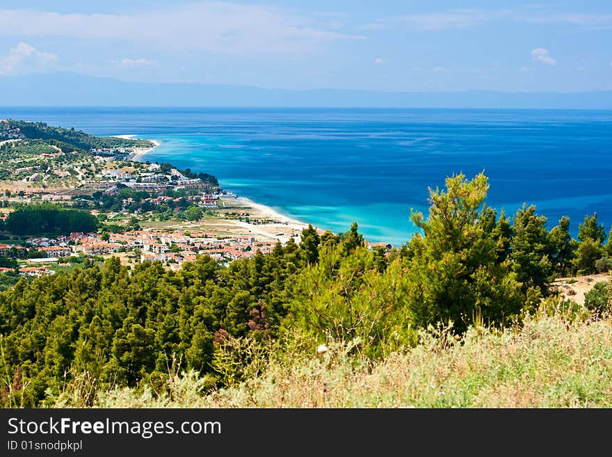 Marine landscape. Greece, Kassandra. Blue sea and sky, small towns with red roofs.