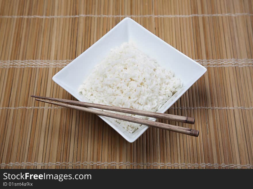 A bowl of perfectly cooked, plain Basmati rice, in an Asian style bowl, with a garnish of Thai Basil. A bowl of perfectly cooked, plain Basmati rice, in an Asian style bowl, with a garnish of Thai Basil