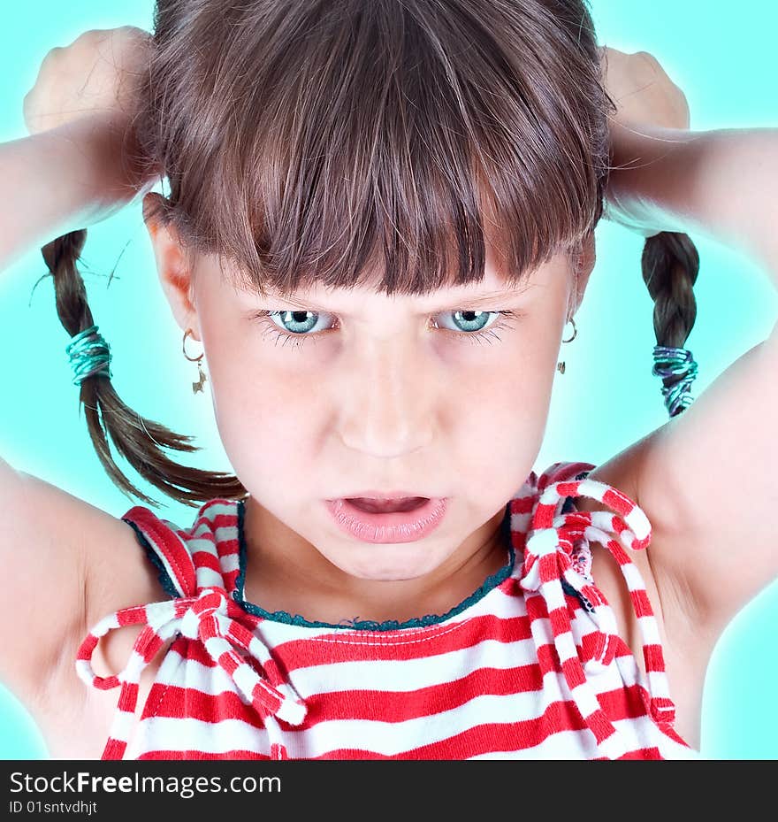 Upset little green eyed girl with pigtails over green background