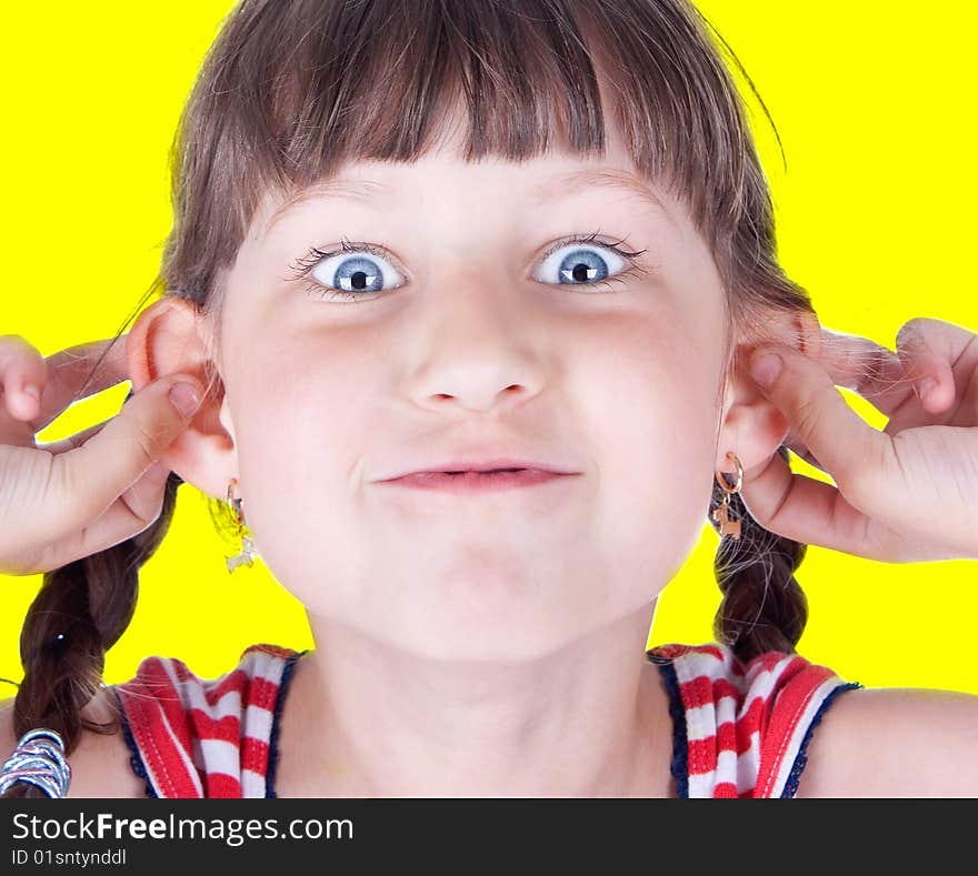 Cute little blue eyed girl making grimace, studio shot