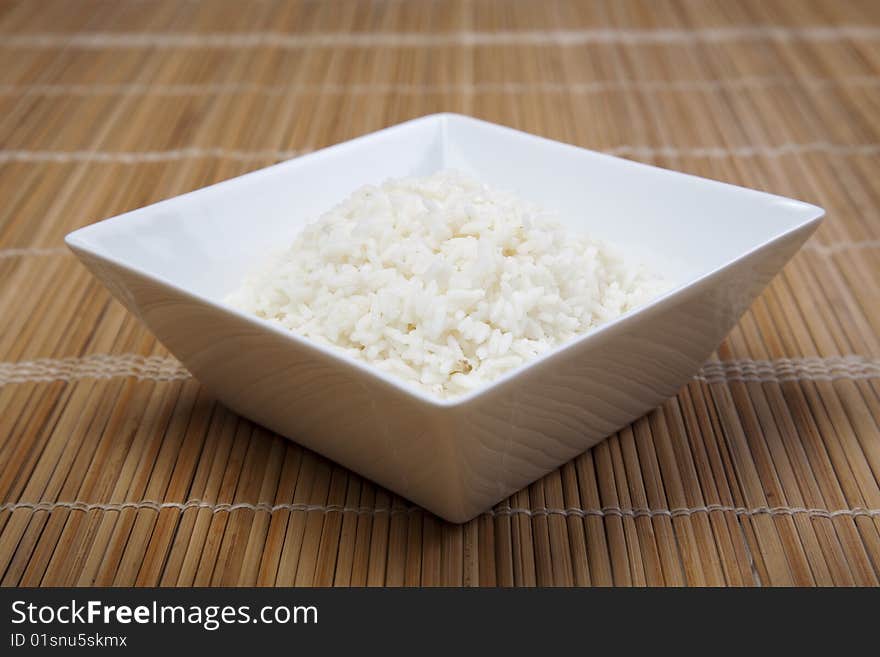 A bowl of perfectly cooked, plain Basmati rice, in an Asian style bowl, with a garnish of Thai Basil. A bowl of perfectly cooked, plain Basmati rice, in an Asian style bowl, with a garnish of Thai Basil