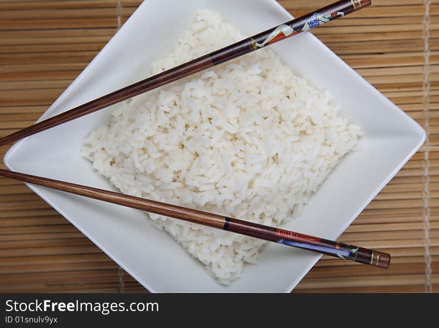 A bowl of perfectly cooked, plain Basmati rice, in an Asian style bowl, with a garnish of Thai Basil. A bowl of perfectly cooked, plain Basmati rice, in an Asian style bowl, with a garnish of Thai Basil