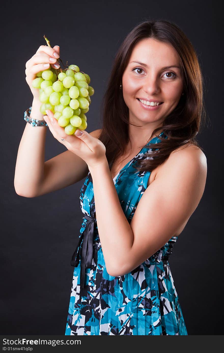 Beautiful girl with grapes cluster