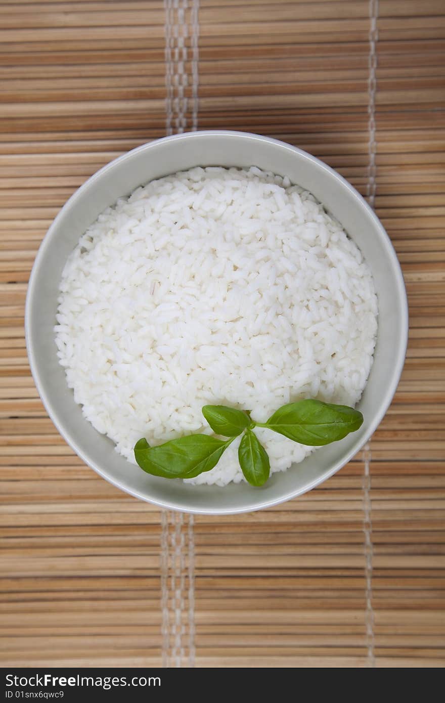 A bowl of perfectly cooked, plain Basmati rice, in an Asian style bowl, with a garnish of Thai Basil. A bowl of perfectly cooked, plain Basmati rice, in an Asian style bowl, with a garnish of Thai Basil