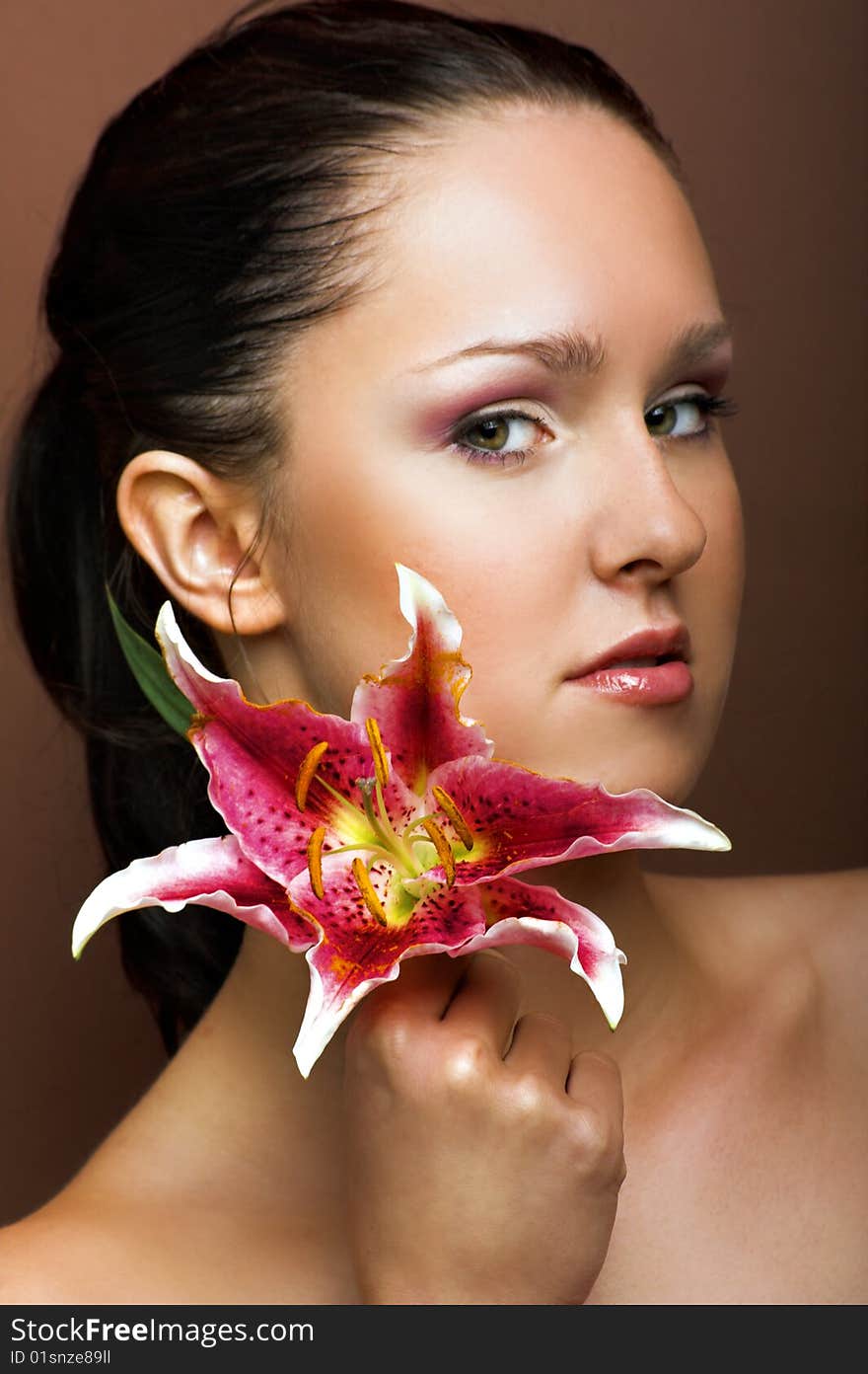 Beauty portrait of a young woman with a lily flower. Beauty portrait of a young woman with a lily flower