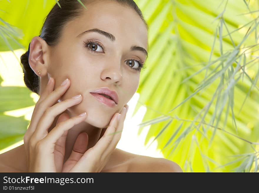 Portrait of young beautiful woman on green leafs back. Portrait of young beautiful woman on green leafs back