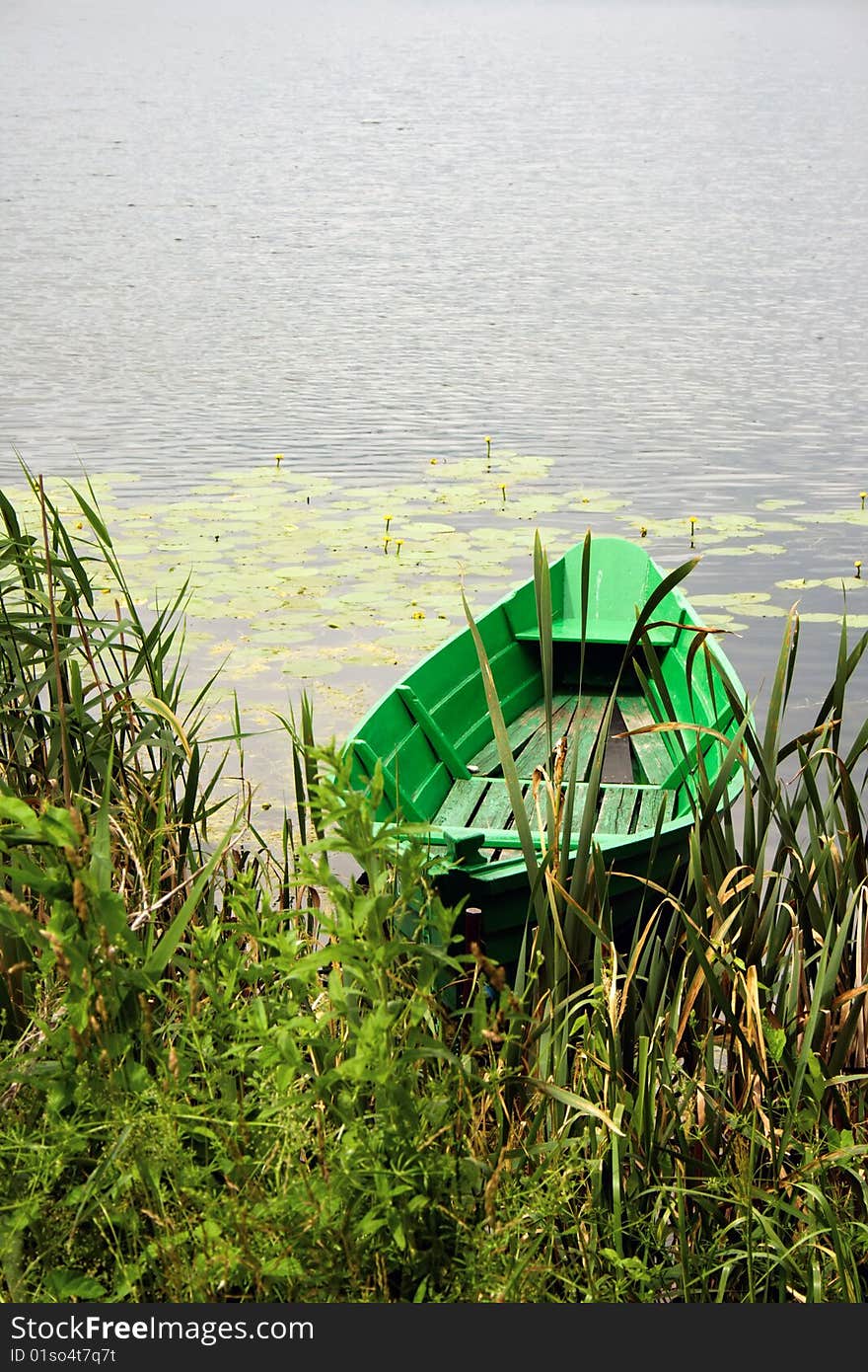 Small green boat on a calm lake