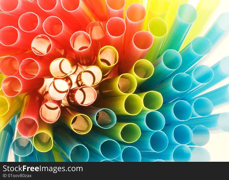 Colored drinking straws in close-up lit from behind