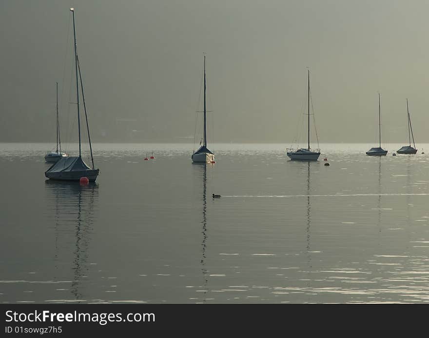 Boats in the early morning fog on lake tegernsee in Germany