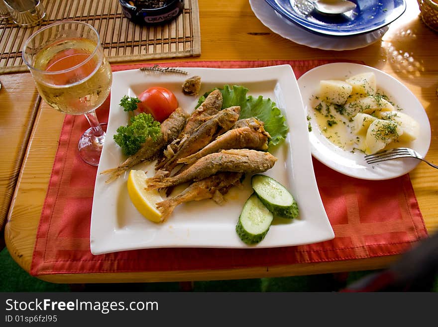 Fried fish and white wine on the table