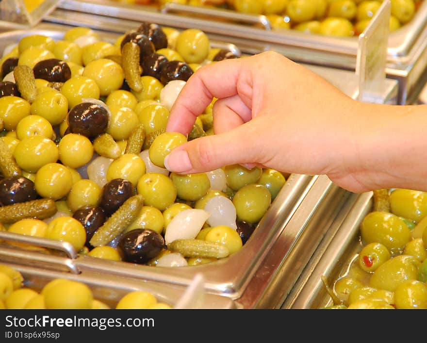 Hand picking up an olive. Hand picking up an olive