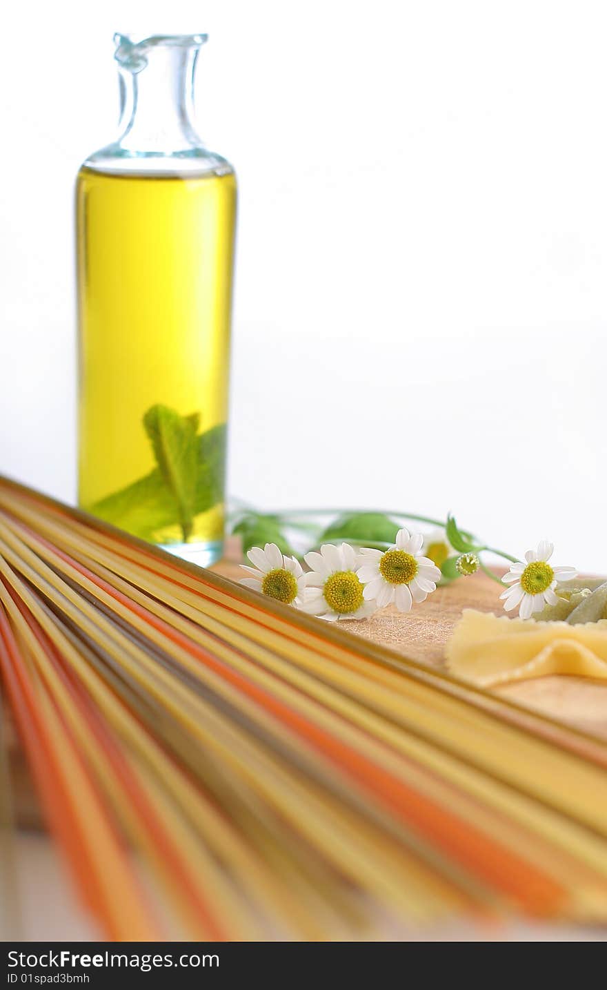 Spaghetti with oil bottle and camomile