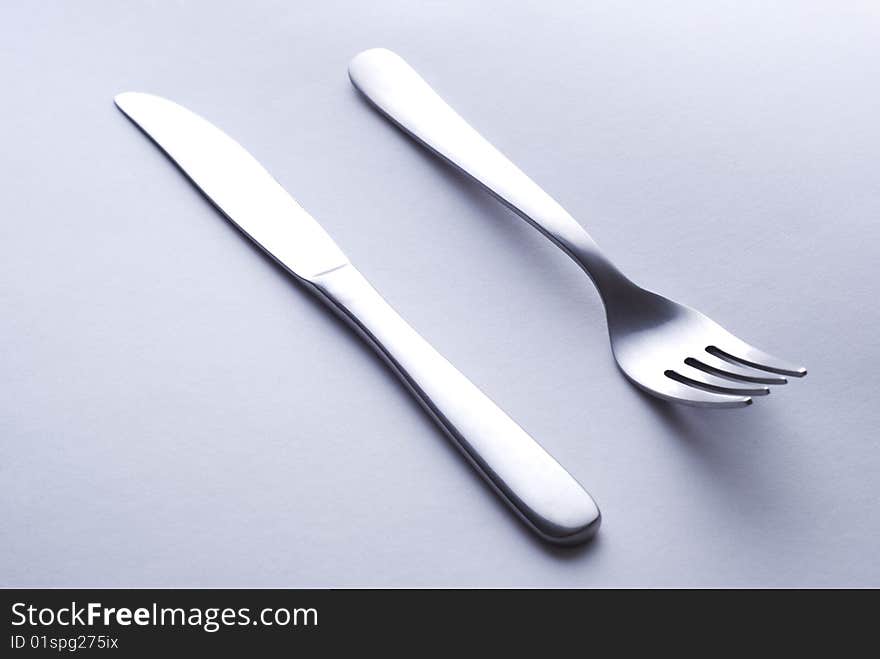 Steel glossy dinnerware on neutral paper background. Steel glossy dinnerware on neutral paper background