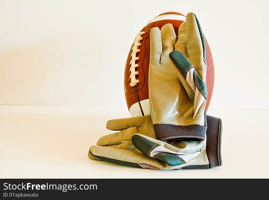 A Pair of Receiver's Gloves Rest on a Football. A Pair of Receiver's Gloves Rest on a Football