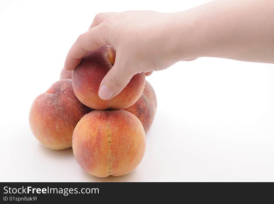 Hand taking a peach. Isolated on white background