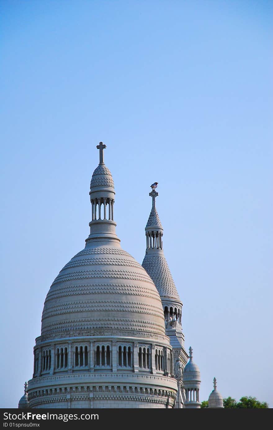 White, European style church architecture with bird perched on roof