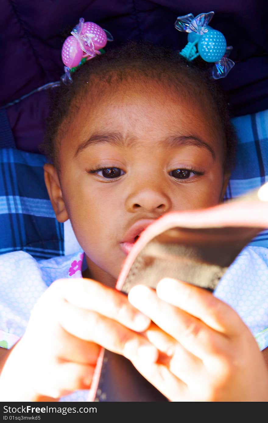 An adorable little girl examining her toy. An adorable little girl examining her toy