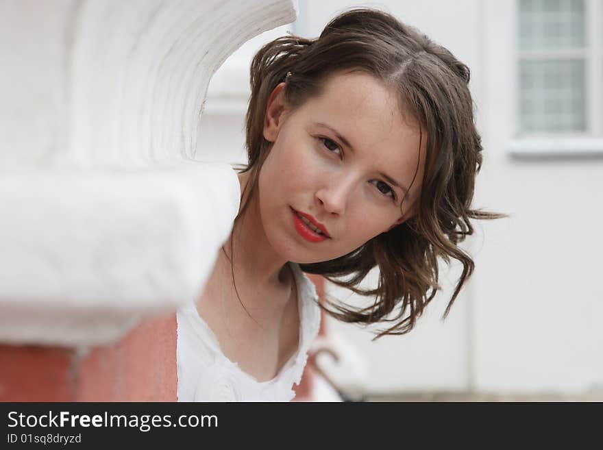 Portrait of the girl looking out because of a corner