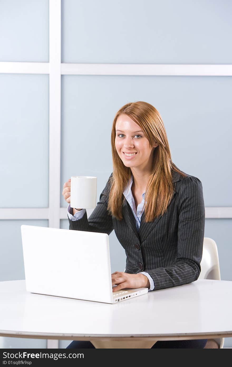 Business woman in modern office with laptop and coffee