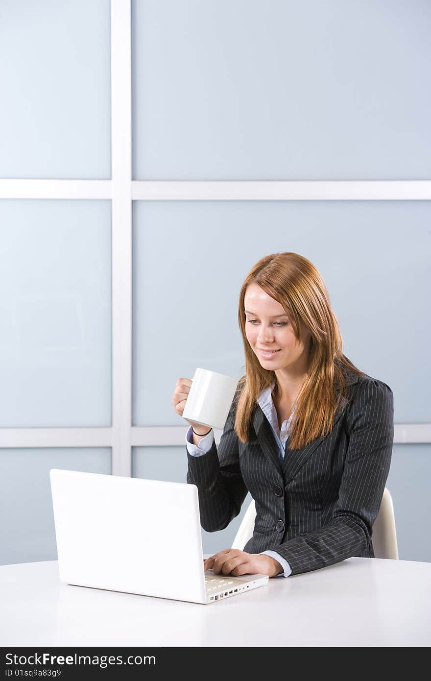 Business woman in modern office with laptop and coffee